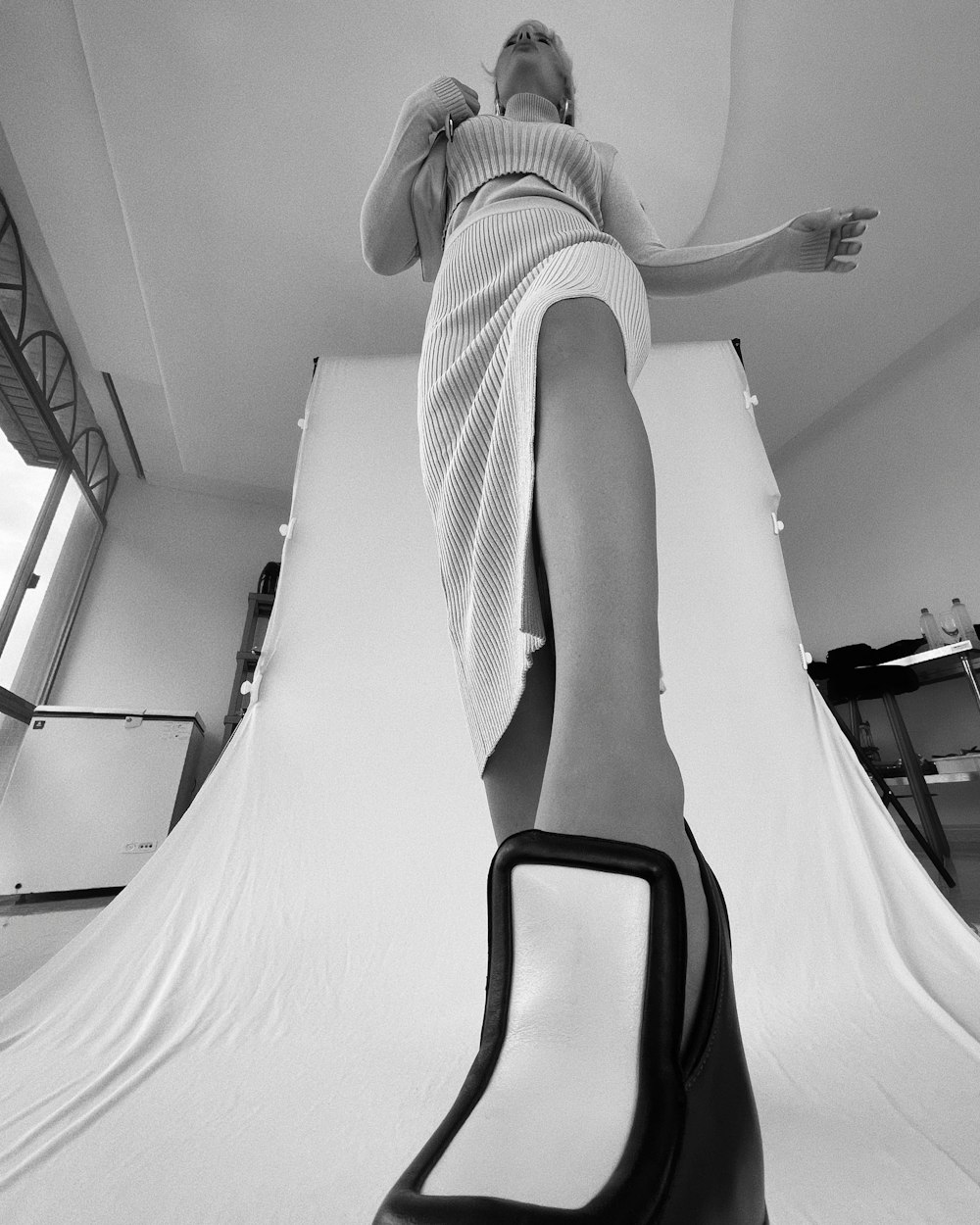 woman in white and black stripe dress sitting on white bed