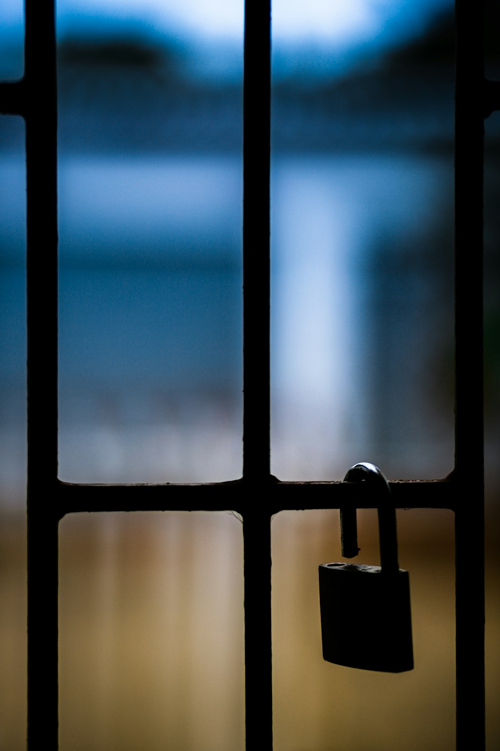 brass padlock on black metal fence