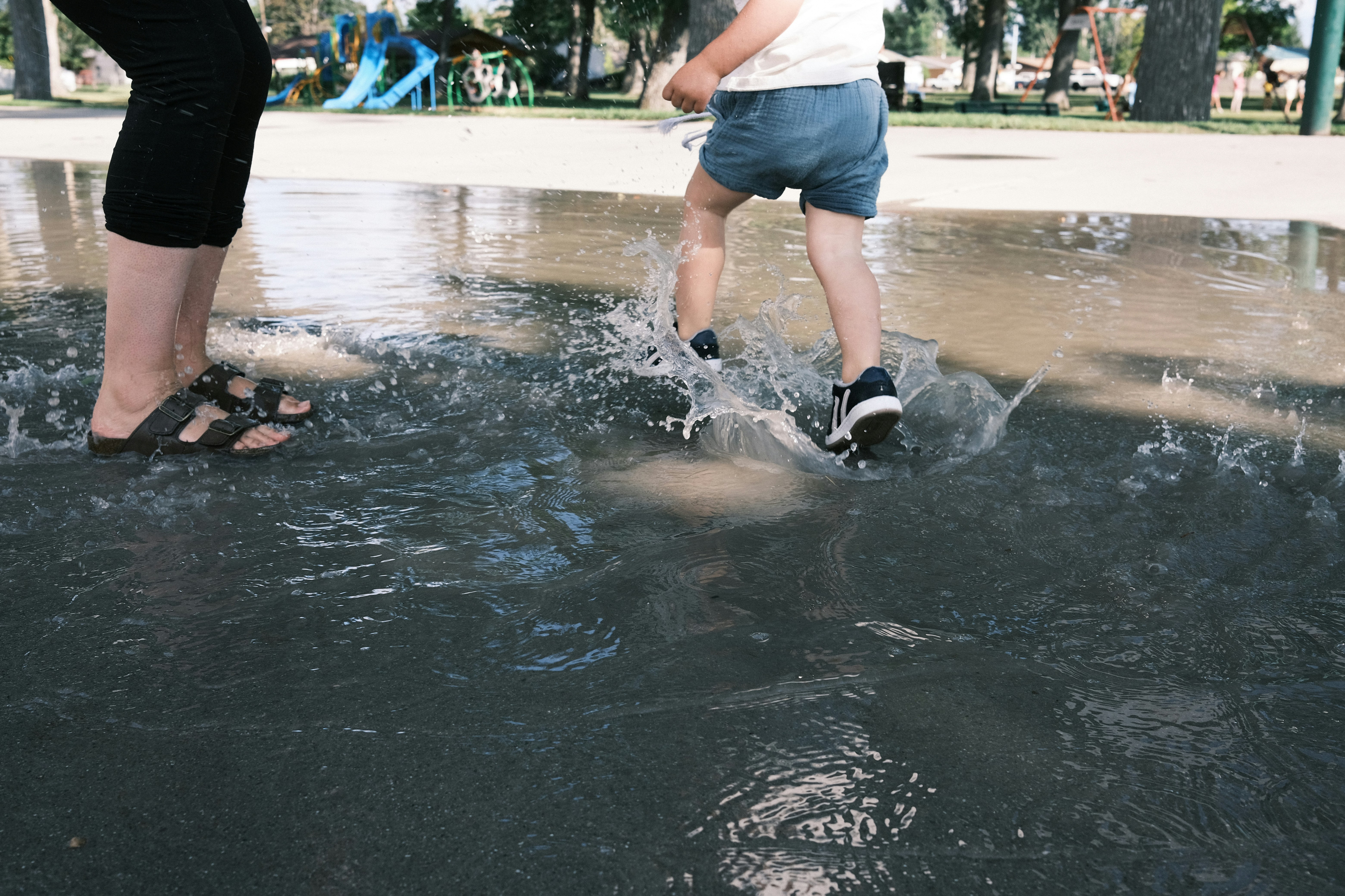 woman in white shirt and blue denim shorts standing on water during daytime