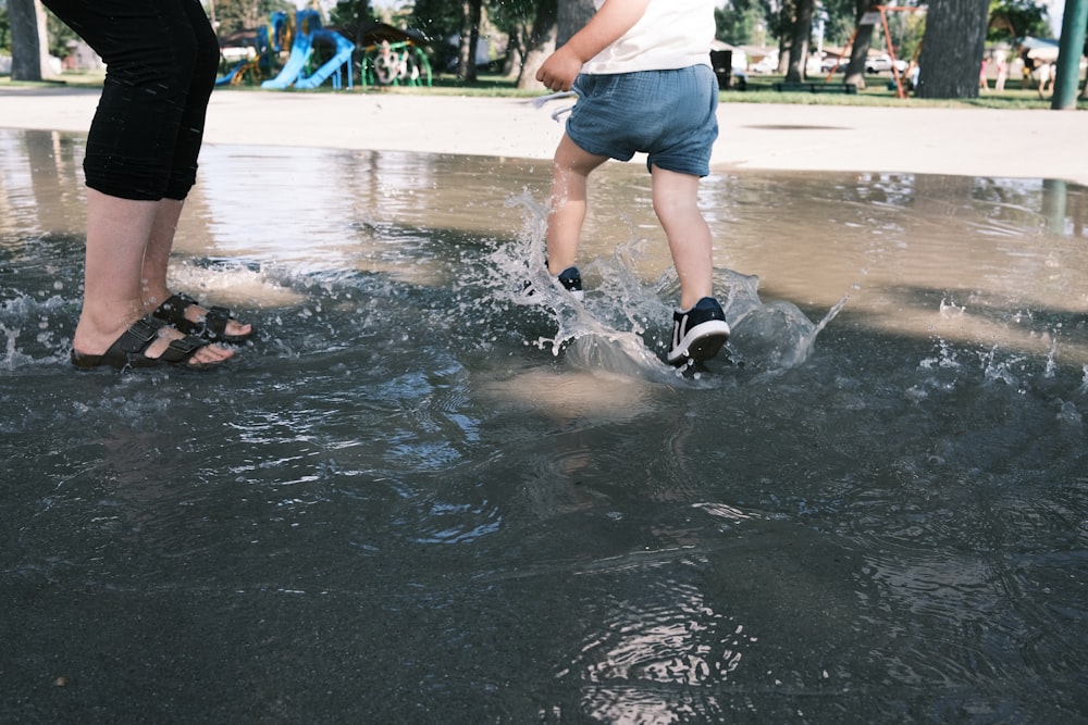 woman in white shirt and blue denim shorts standing on water during daytime