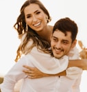 man in white dress shirt hugging woman in white dress