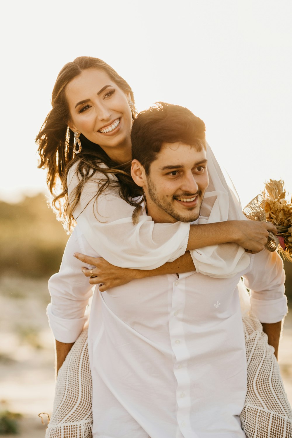 man in white dress shirt hugging woman in white dress