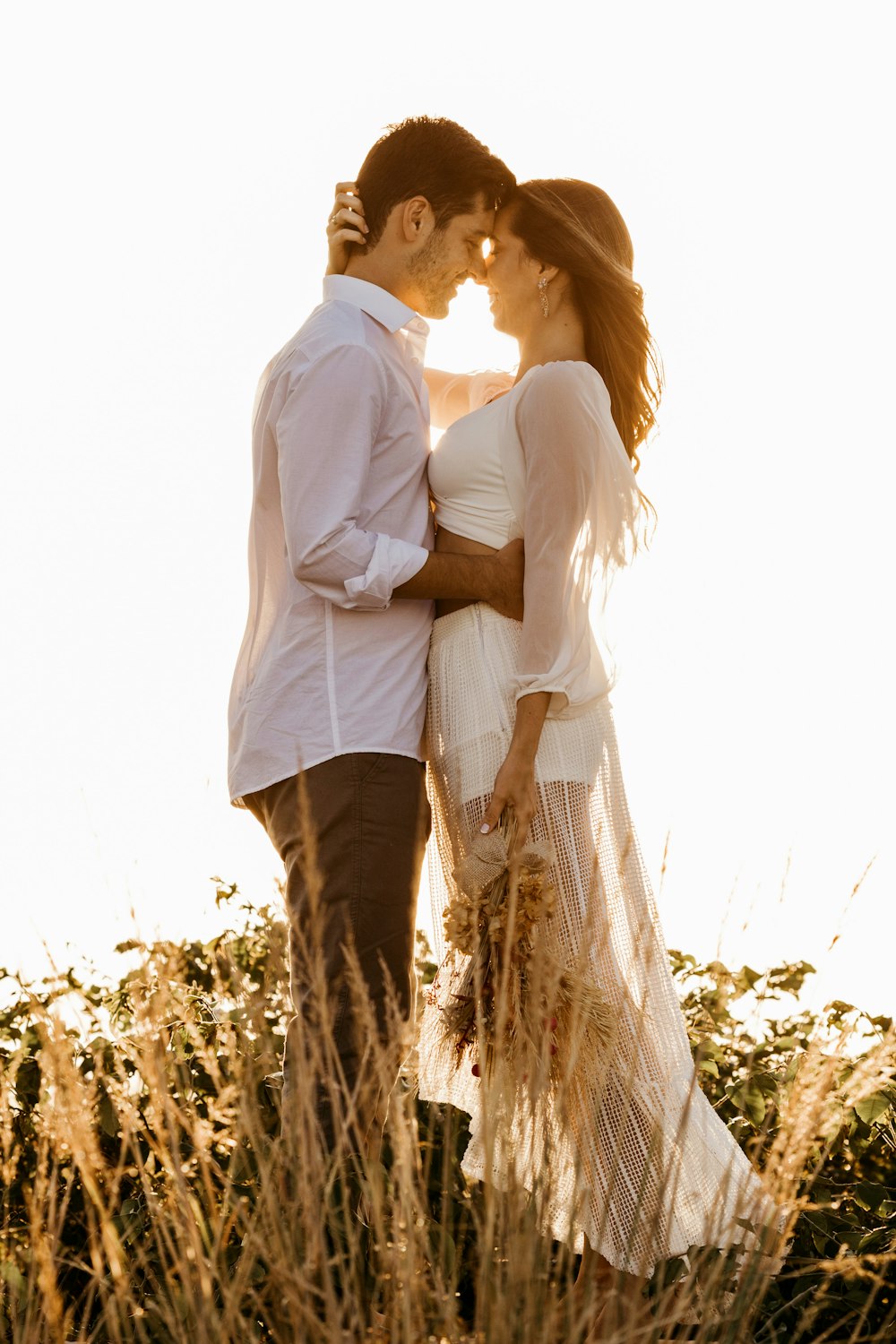 man in white dress shirt and brown pants standing beside woman in white dress shirt