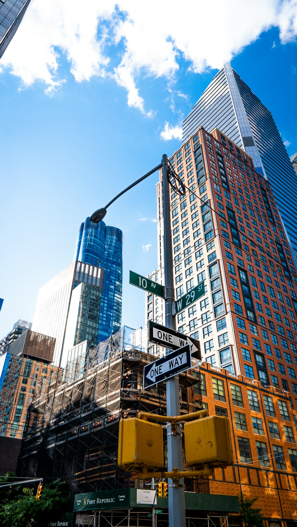 city buildings with green and white street sign during daytime