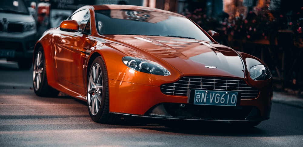 orange porsche 911 parked on road during daytime