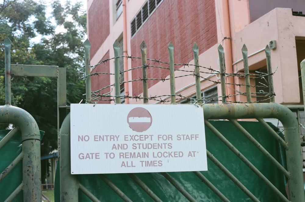 green metal fence near brown concrete building during daytime