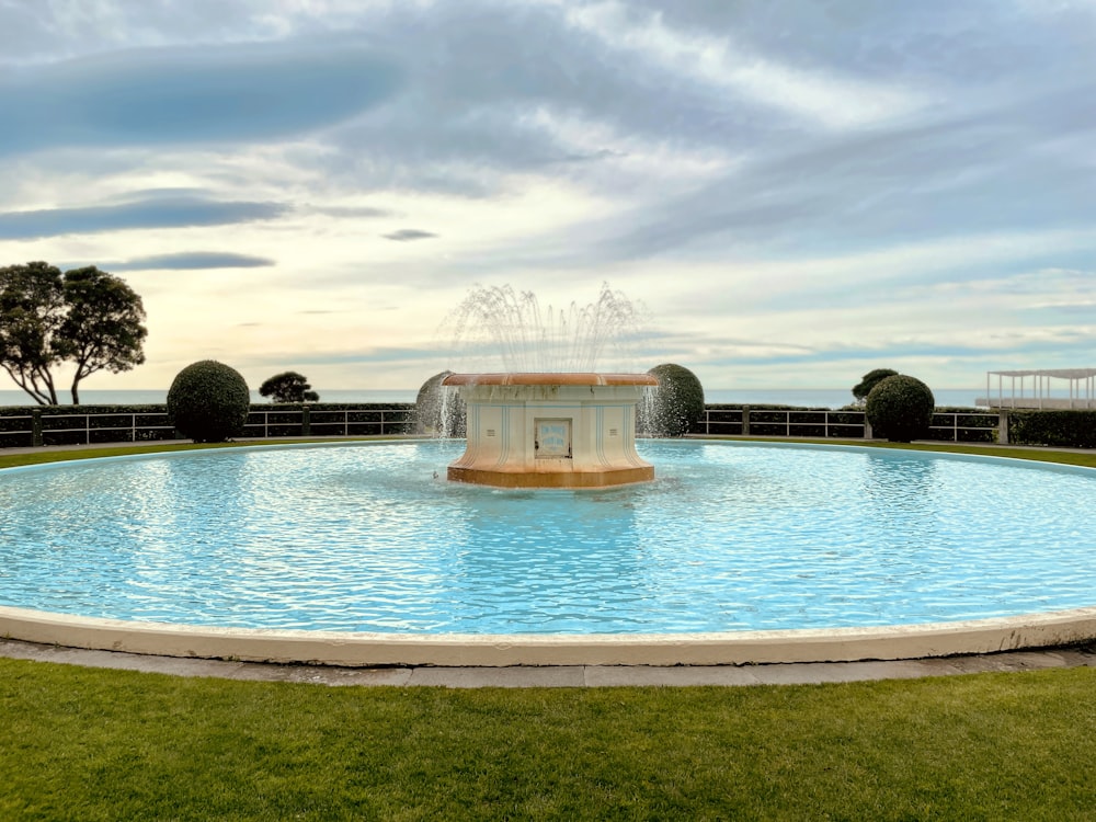 Weißes Betongebäude in der Nähe von Schwimmbad unter blauem Himmel tagsüber