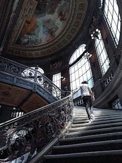 man in black and white stripe shirt and black pants walking down the stairs
