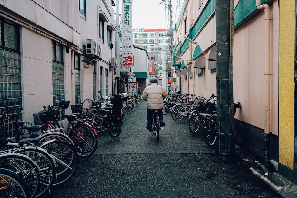 man in white jacket and black pants walking on sidewalk during daytime