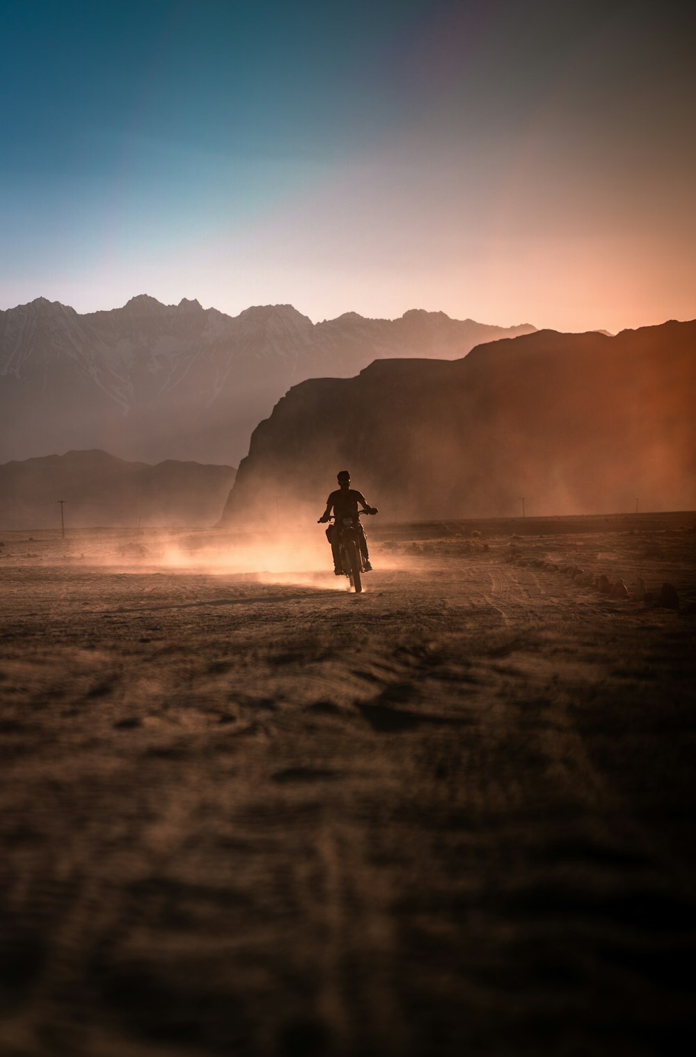 silhouette of person standing on seashore during sunset