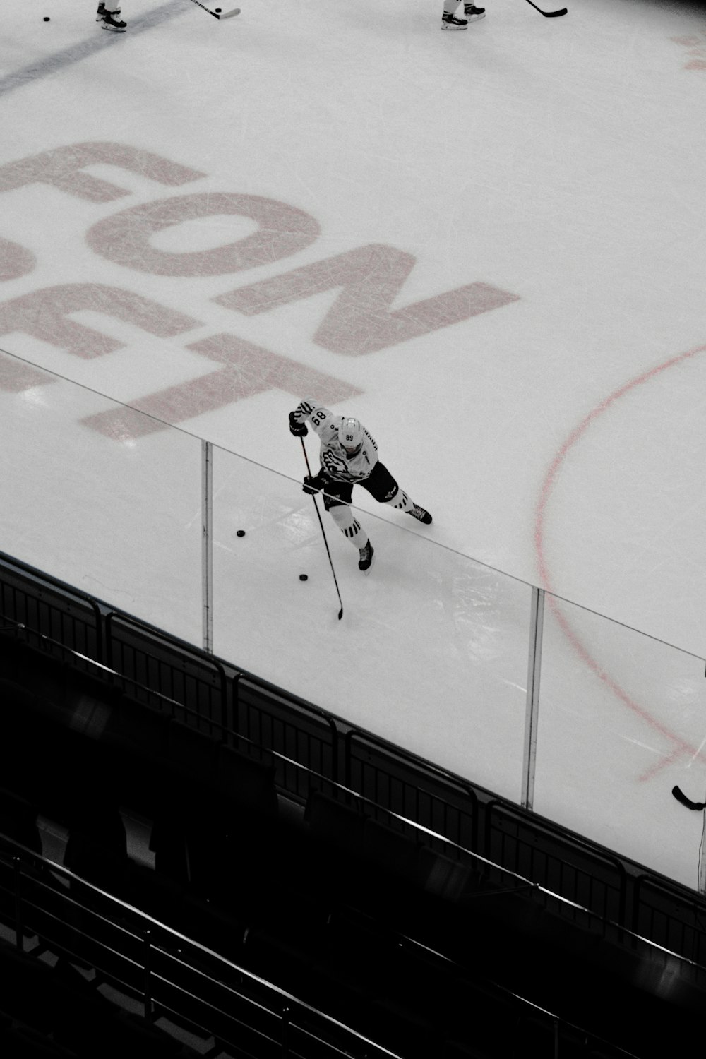 Homme en maillot de hockey sur glace blanc et noir et pantalon noir sur une planche à roulettes noire