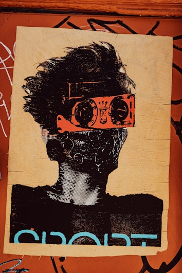 A stylized piece of street art depicts a person with wild hair. The character wears bright orange goggles and a patterned mask, giving a futuristic or rebellious vibe. The background is a textured brown surface with graffiti and the word 'SPORT' partially visible in bold letters.