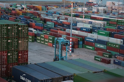 A diverse range of shipping containers stacked at a bustling port, ready for transport.