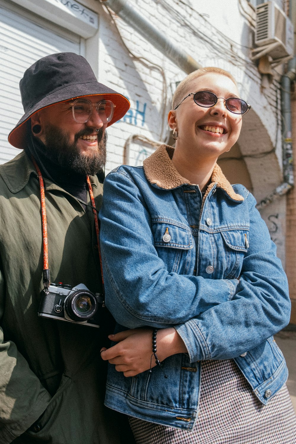 man in blue denim jacket holding black camera