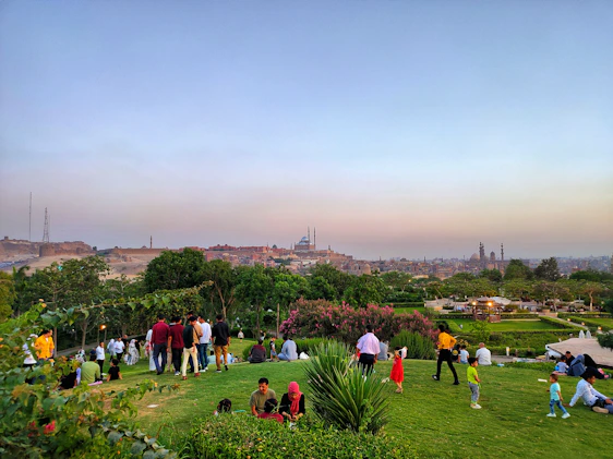 A vibrant panoramic view of Qiddiya City with families enjoying outdoor activities under a clear blue sky.