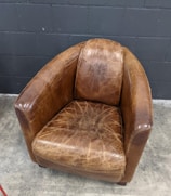 An antique leather armchair with a worn patina, inviting and cozy.