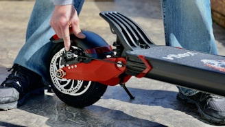 person holding red and black motorcycle