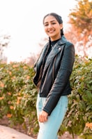 man in black leather jacket standing near green plants during daytime