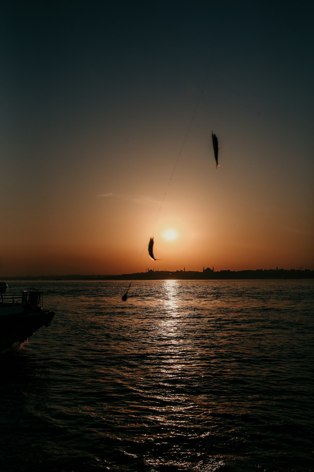 silhouette of boat on sea during sunset