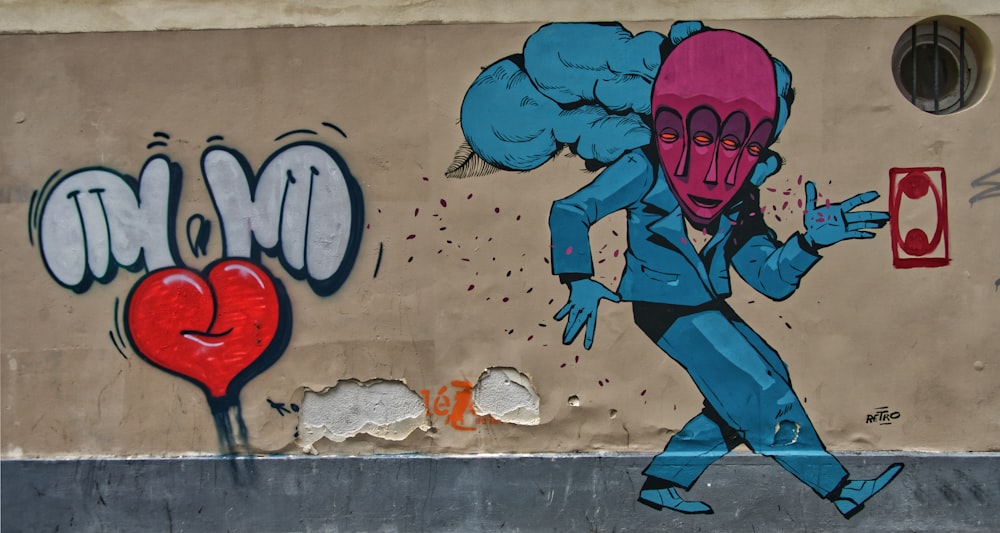man in blue shirt and blue pants wall graffiti