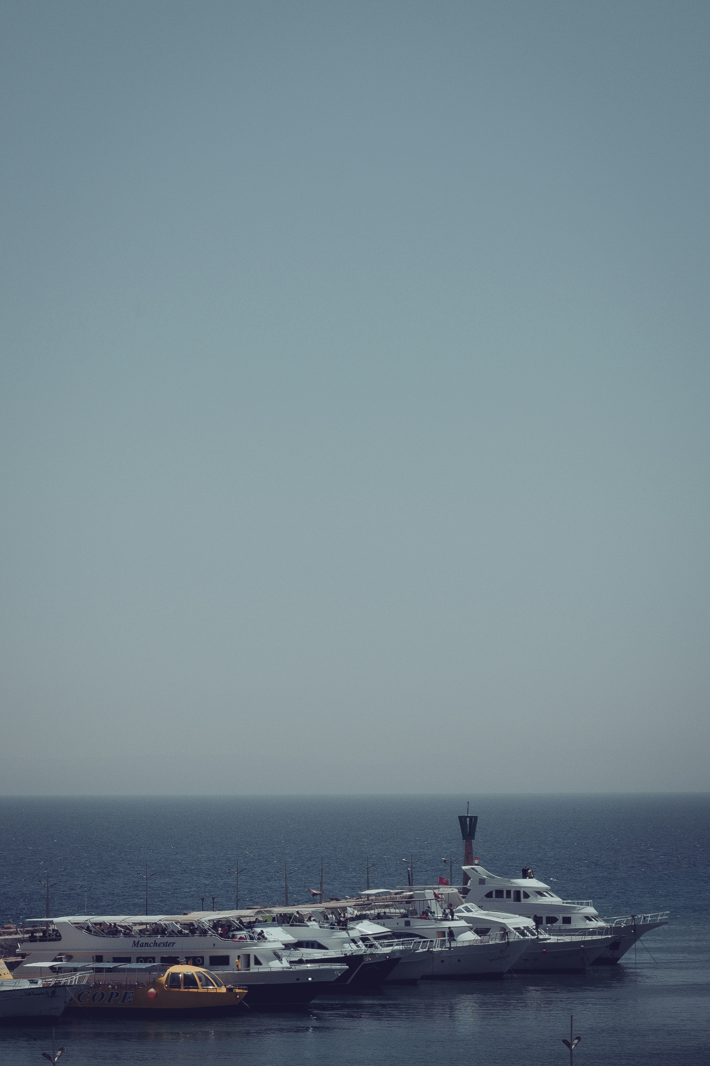 2 people standing on the beach during daytime