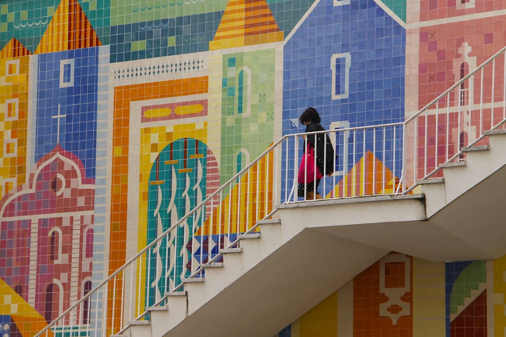 woman in black jacket standing on white staircase