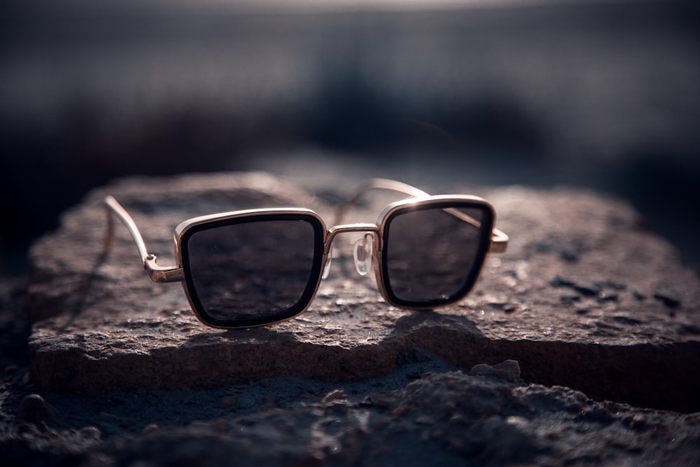 black framed eyeglasses on brown sand during daytime