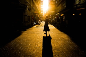 woman in black dress walking on sidewalk during night time