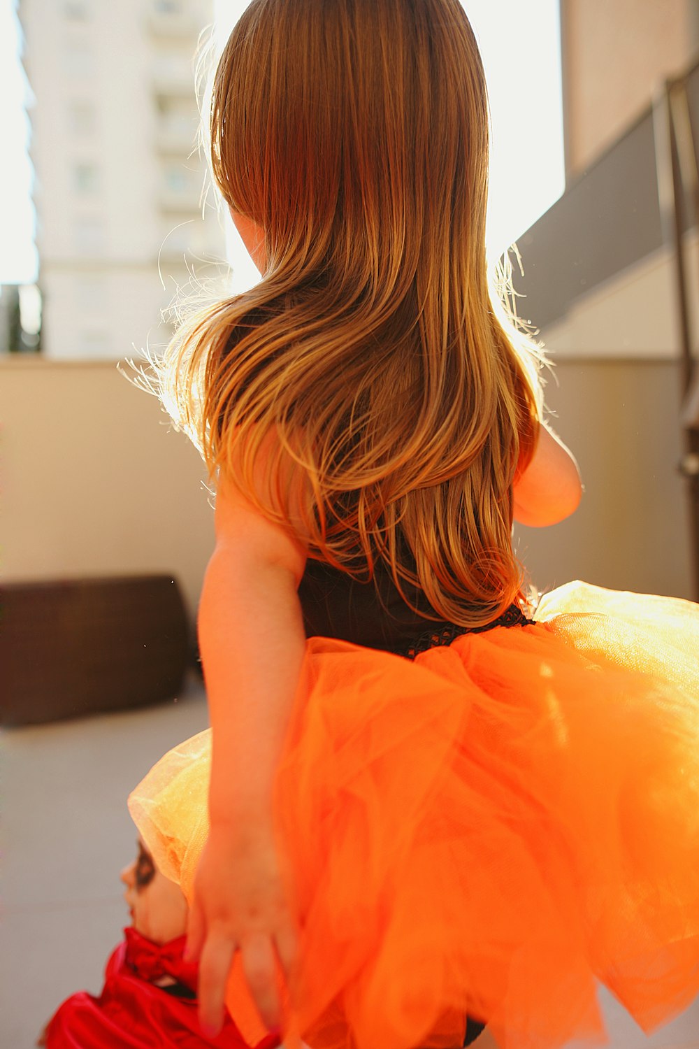 woman in orange dress sitting on white bed