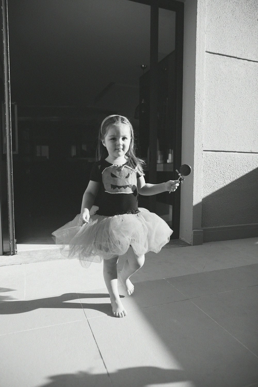 girl in black dress standing on white floor tiles