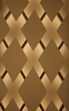 A minimalist bronze diamond symbol glowing softly on a textured fabric background.