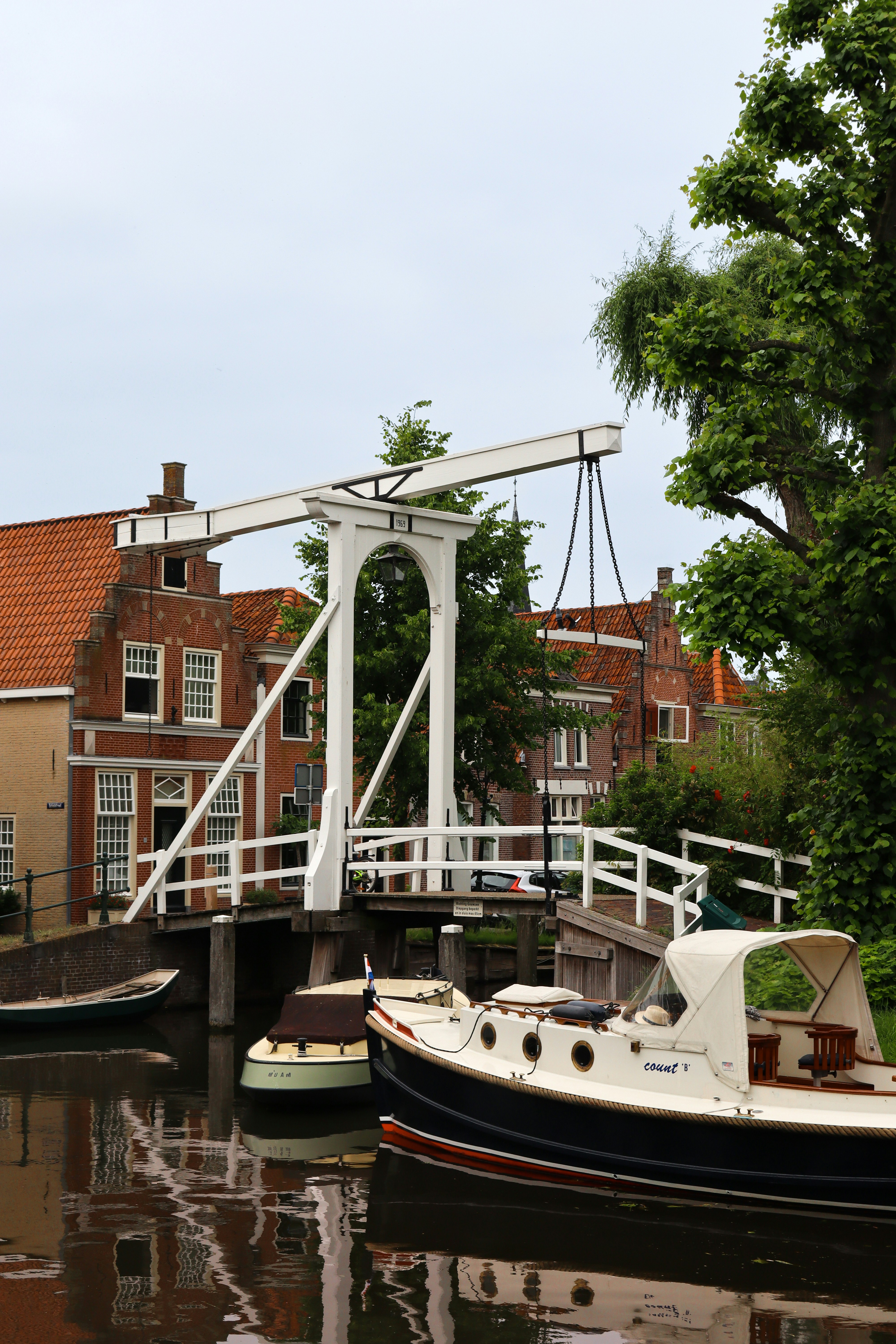 white and brown boat on river near brown concrete building during daytime
