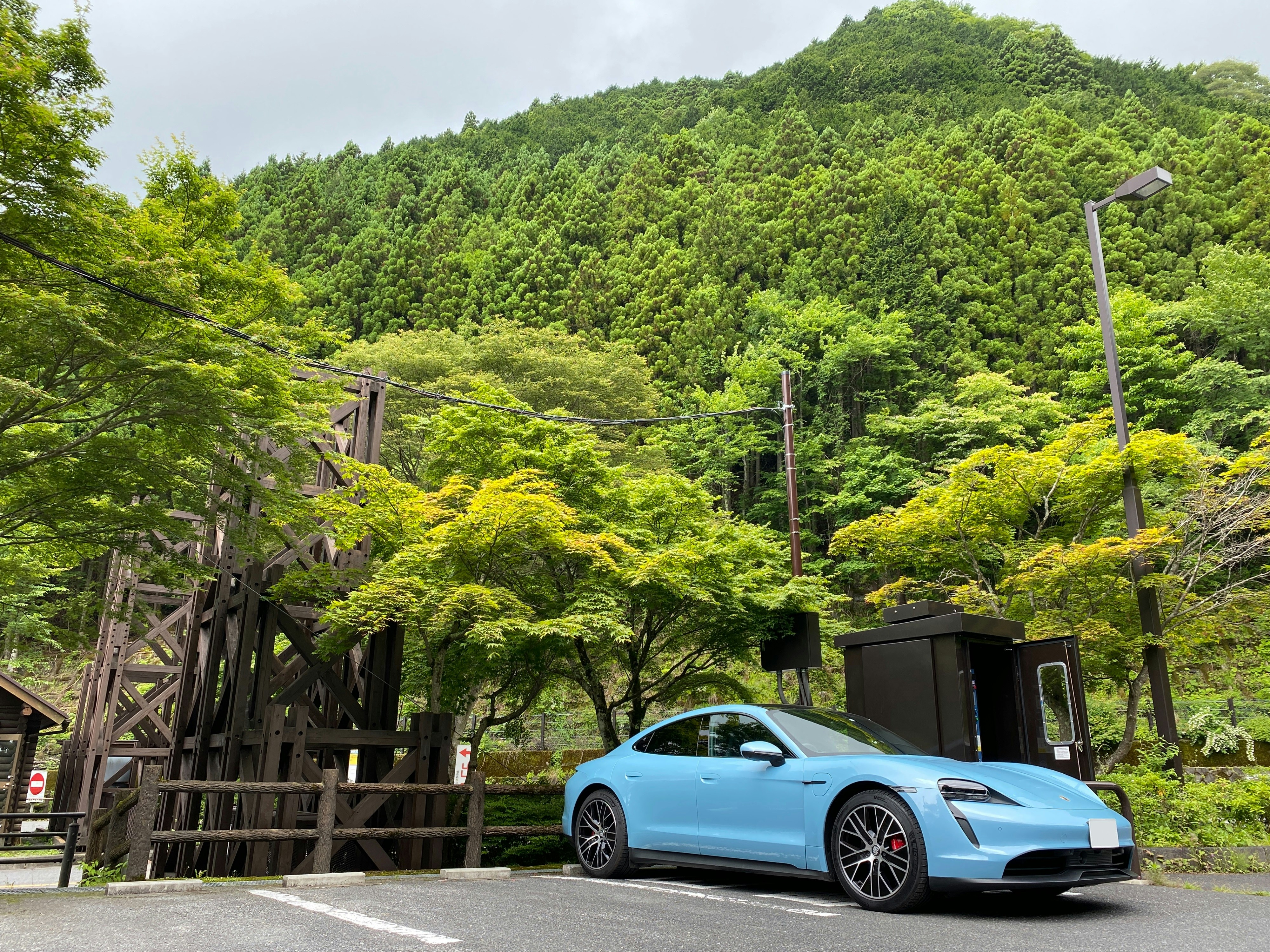 blue coupe parked on wooden bridge