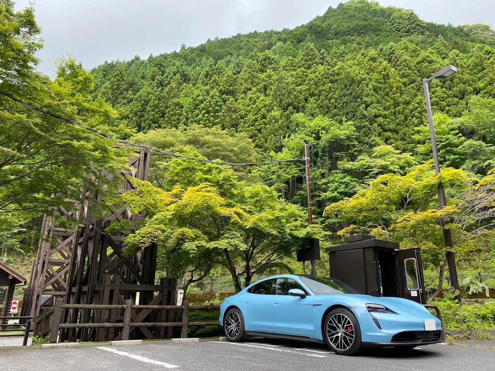 blue coupe parked on wooden bridge