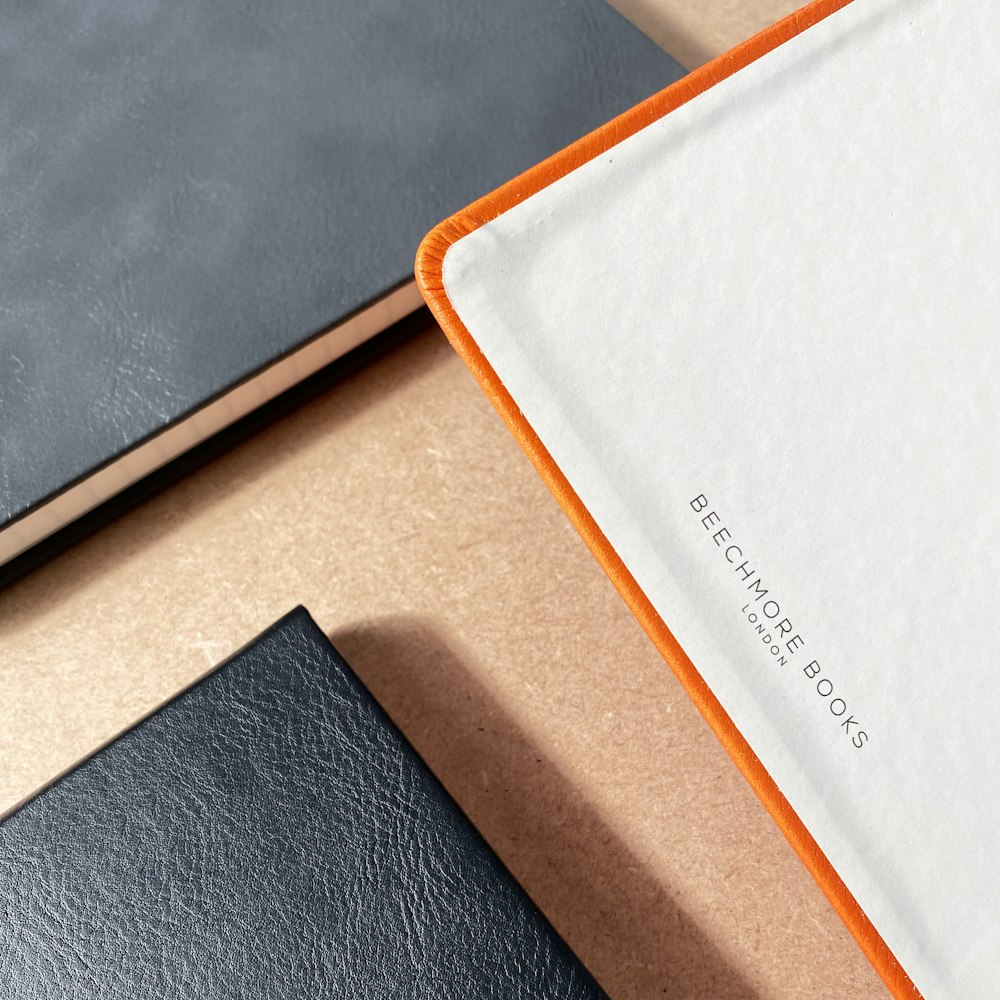 white and orange book on black leather textile