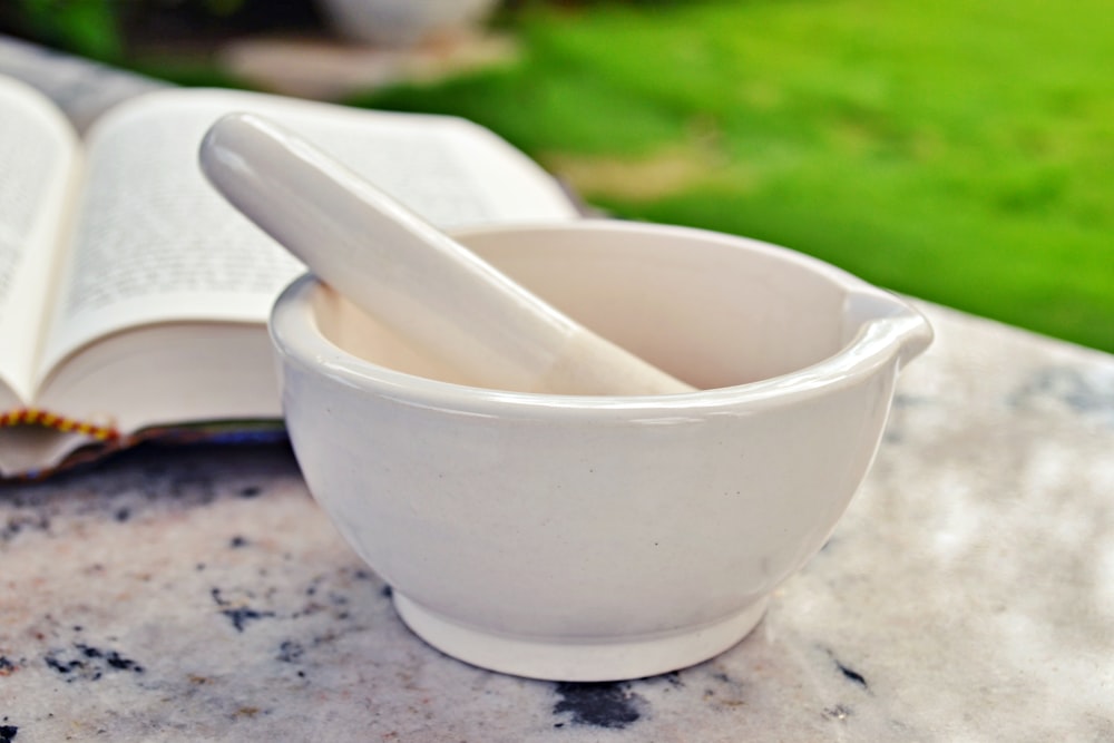 white ceramic mortar and pestle on brown wooden table