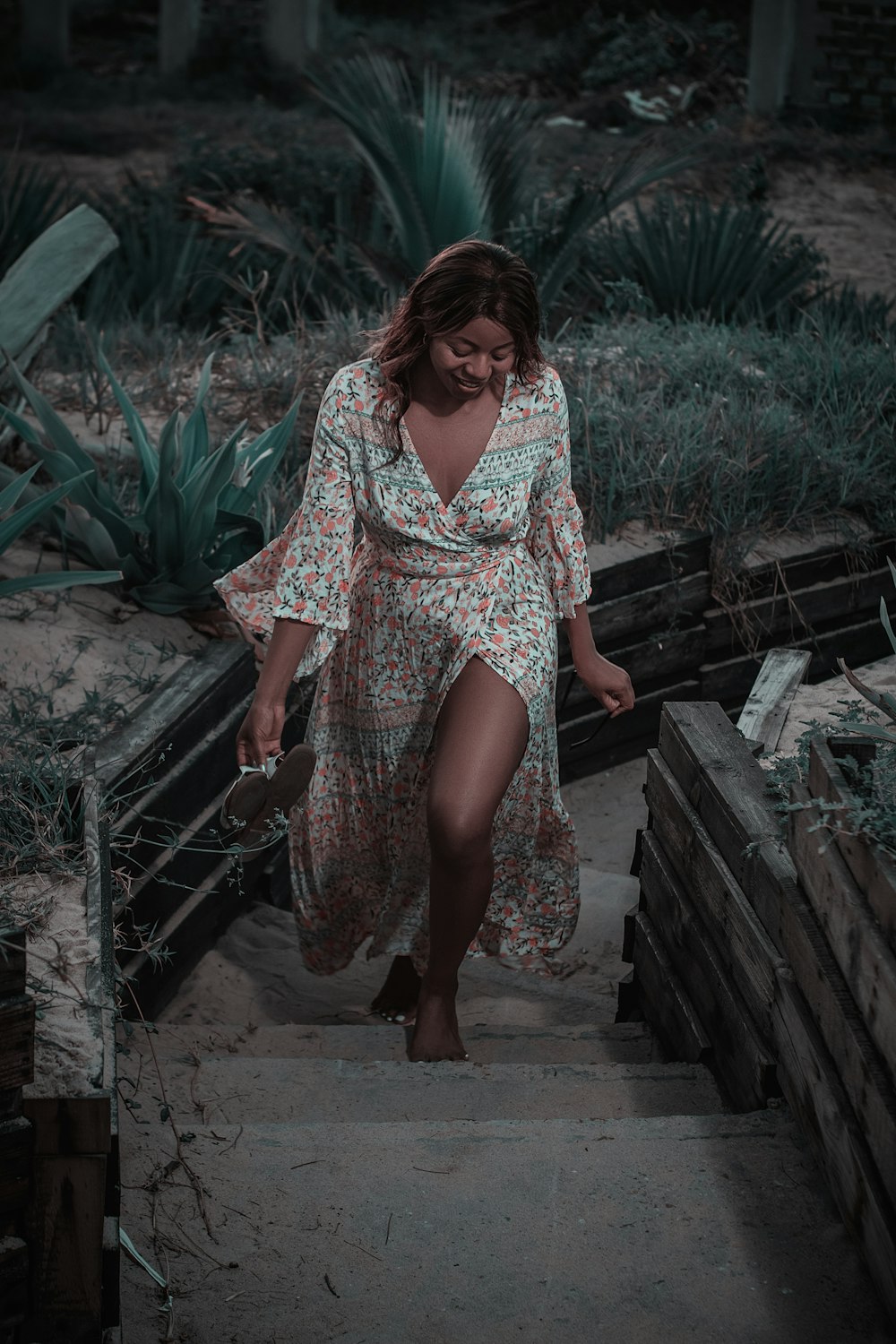 woman in red and white dress standing on brown wooden stairs