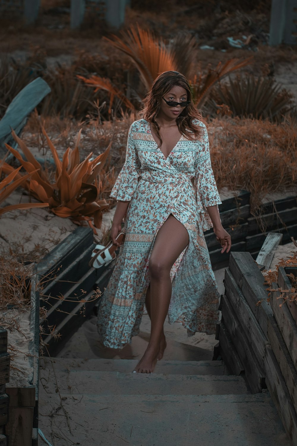 woman in white and blue floral dress standing on brown wooden boat