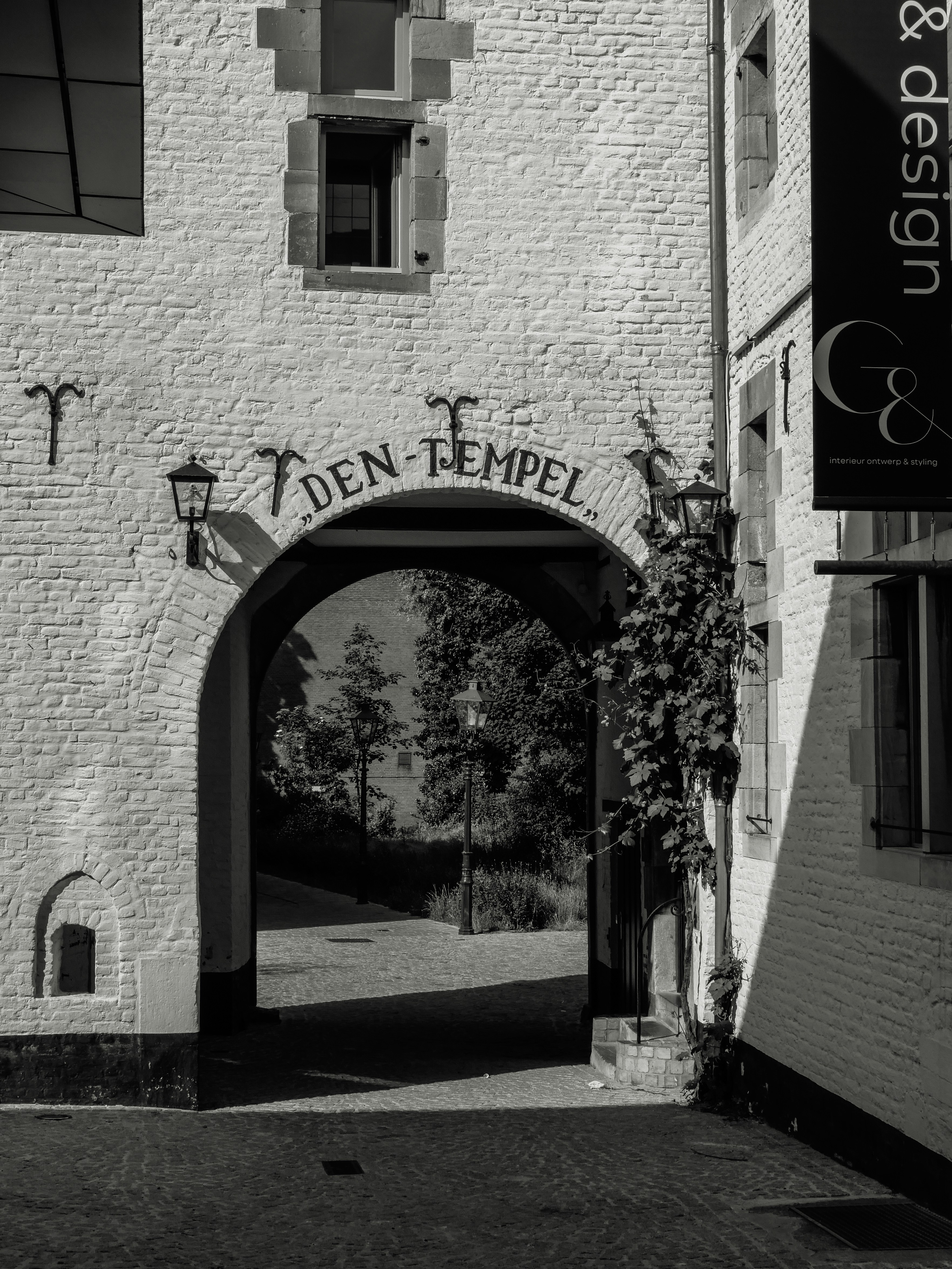 brown brick building with green trees and grass