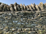 Close-up of a carefully stacked natural stone wall under bright daylight.