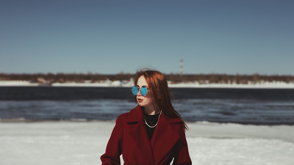 a woman in a red coat is standing in the snow