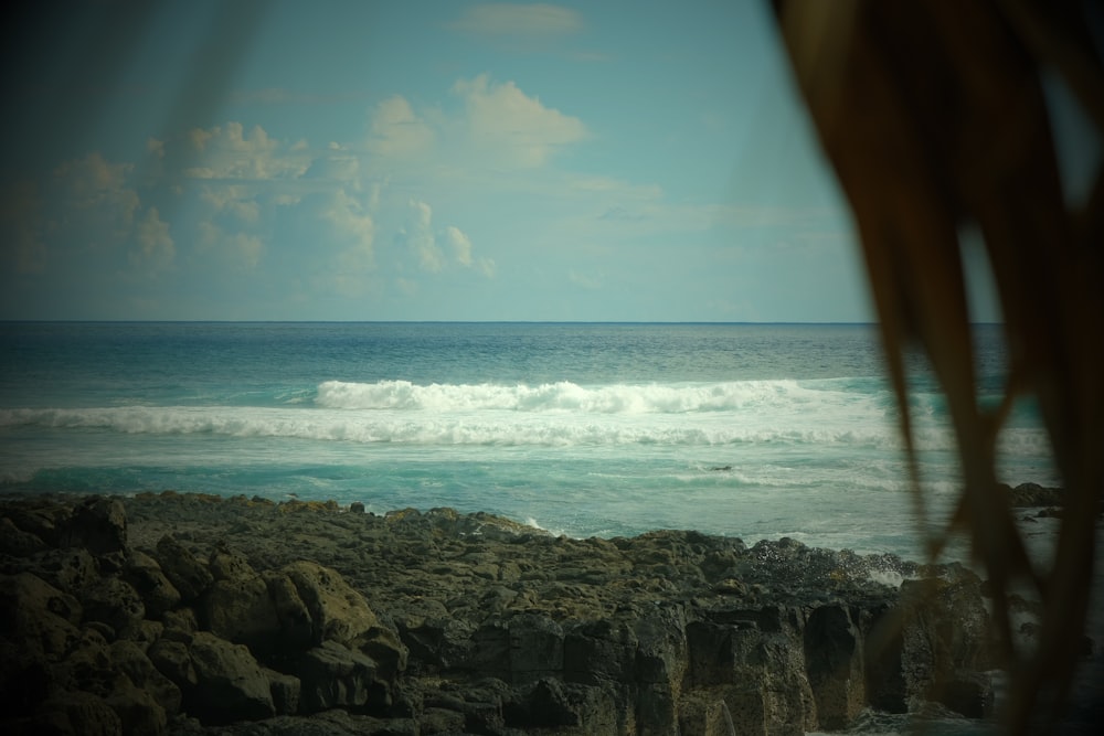 ocean waves crashing on rocky shore during daytime