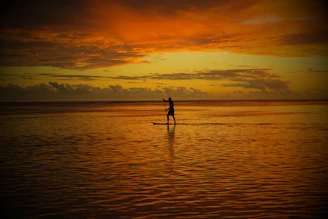 A dynamic shot of the PumpPro Active sup air pump in action, inflating a standup paddleboard against a vibrant sunset backdrop.