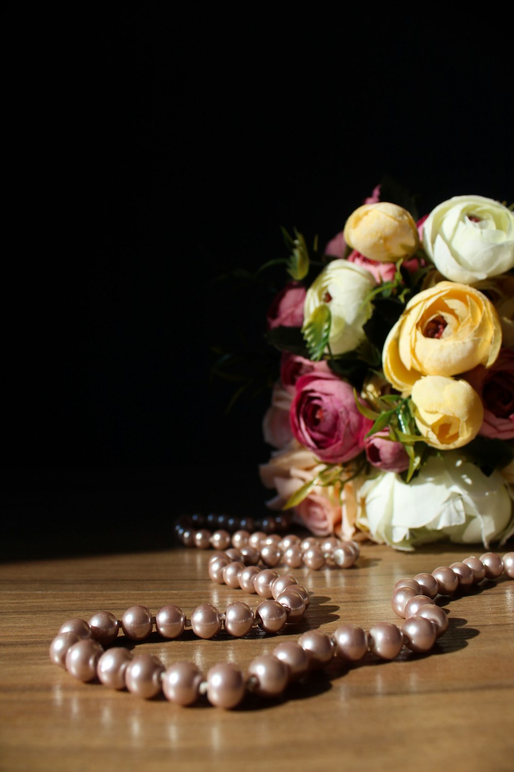 rosas rosas y amarillas sobre mesa de madera marrón