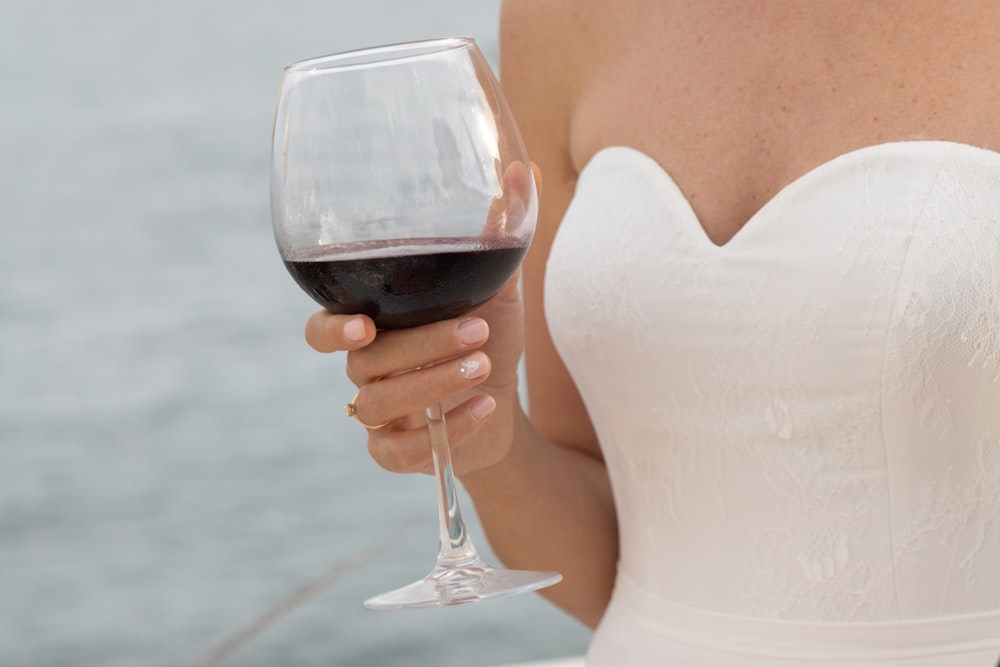 woman in white tank top holding wine glass