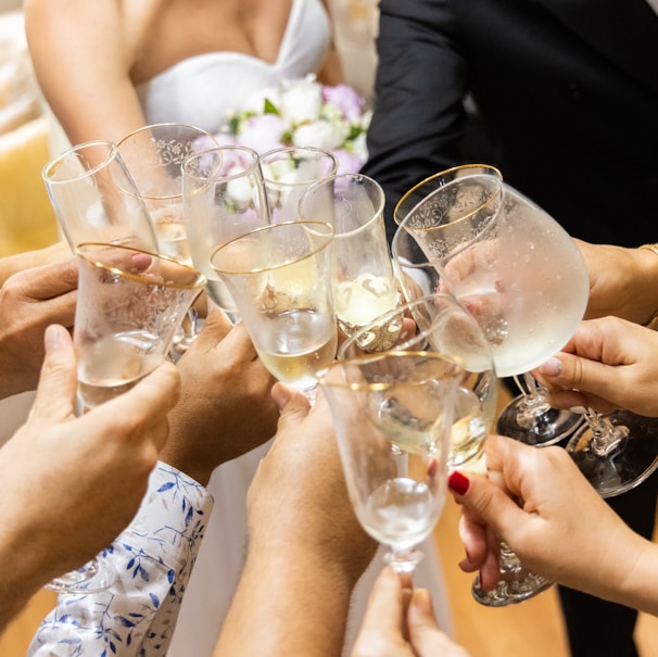 woman in white wedding dress holding clear wine glass