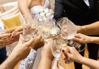 woman in white wedding dress holding clear wine glass