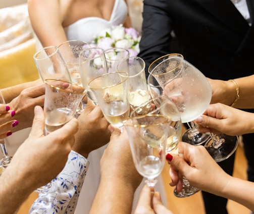 woman in white wedding dress holding clear wine glass