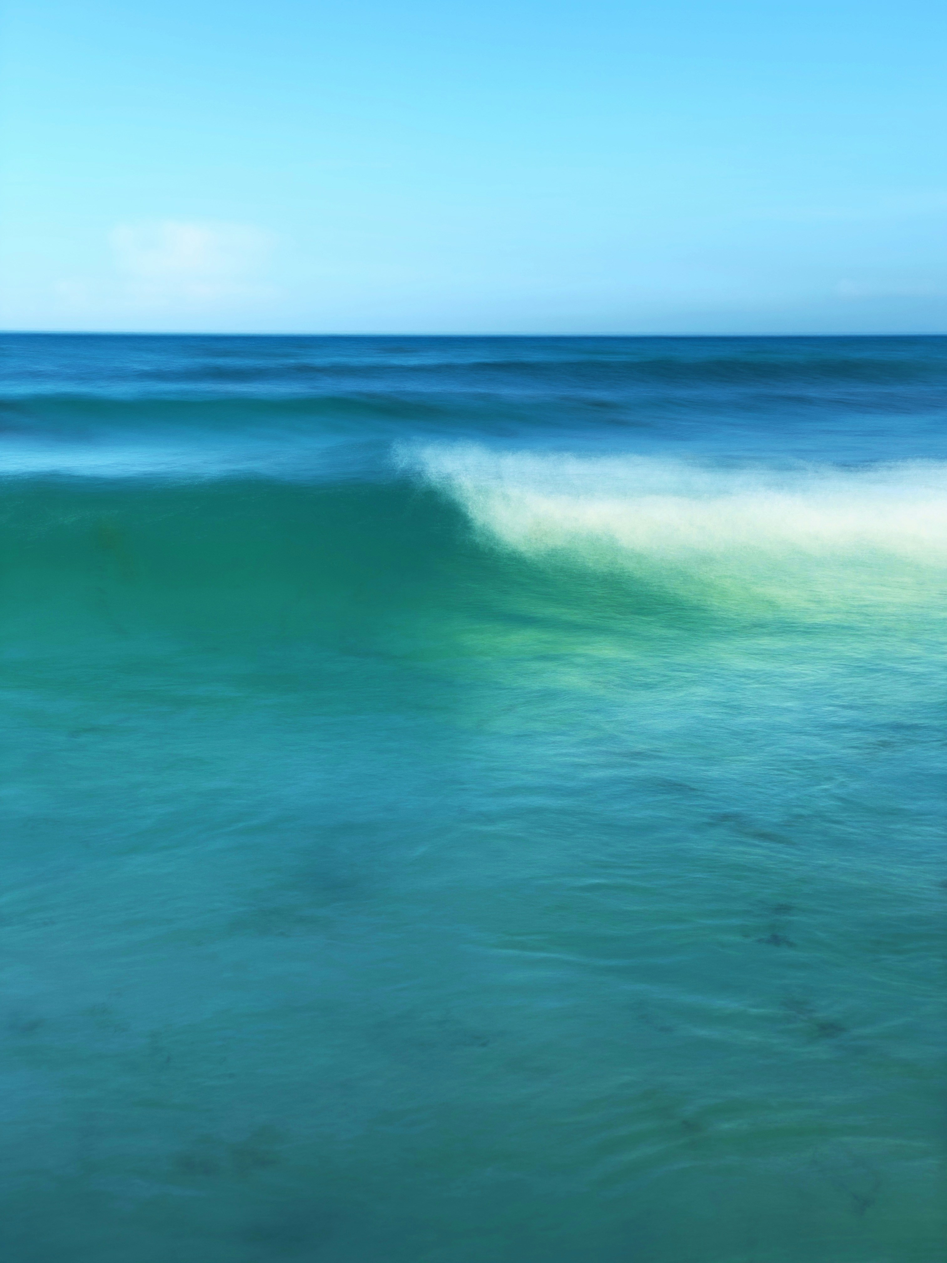 ocean waves under blue sky during daytime