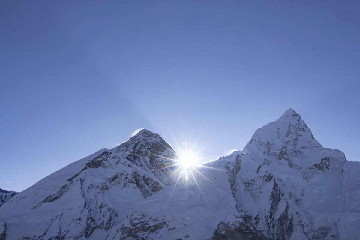 Helicopter landing at Namche Bazaar with Everest visible behind the ridge in clear morning air